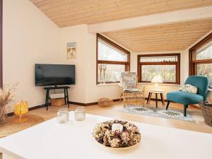 ein Wohnzimmer mit einem Flachbild-TV und einem Tisch in der Unterkunft 8 person holiday home in L kken in Lønstrup