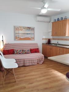a living room with a couch and a kitchen at Rico Apartaments Parador in Nerja