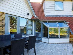 a patio with a table and chairs and windows at 7 person holiday home in Lemvig in Trans