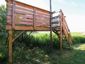 a wooden bench sitting in the grass with a ladder at 7 person holiday home in Lemvig in Trans