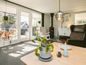 una sala de estar con una mesa con una planta en Three-Bedroom Holiday home in Blåvand 21, en Blåvand