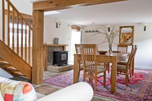 a dining room with a table and chairs and a fireplace at Nether Farm Barns in Ashbourne