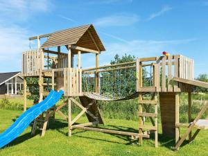 a wooden playset with a slide and a slideintend at 14 person holiday home in Idestrup in Marielyst