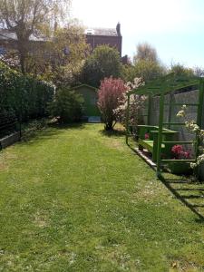 een tuin met een bank en een prieel bij Au galet bleu in Dieppe