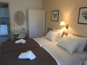 a hotel room with two white towels on a bed at Villa Tina Country Beach Apartments in Acharavi