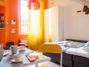 a room with orange walls and a bed and a table at The Best Rent - Studio Apartment close to Cinque Giornate in Milan