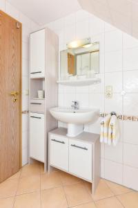 a bathroom with a sink and a mirror at Ferienwohnungen im Haus Trudi in Bensersiel