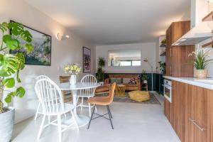 cocina y sala de estar con mesa y sillas en T3 centre proche plage avec parking privatif en Biarritz