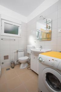 a bathroom with a toilet sink and a washing machine at Apartment Pepi in Lovran