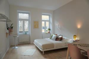 biała sypialnia z łóżkiem i dwoma oknami w obiekcie Modern 2Br Apartments - Full Kitchen - Schönbrunn Area - 15 Mins to City Center w Wiedniu