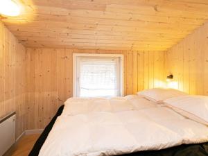 ロッケンにあるHoliday Home Aksel Munchsvejの窓付きの木製の部屋の大型ベッド1台