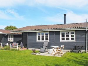 a black house with a table and chairs in a yard at Holiday home Vordingborg V in Vordingborg