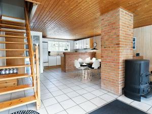 - une cuisine avec un mur et un poêle en briques dans l'établissement 8 person holiday home in Bl vand, à Blåvand