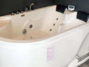 uma banheira branca sentada num quarto em 10 person holiday home in Hadsund em Hadsund