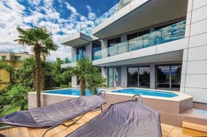 a large building with a swimming pool and a house at Apartments Marjanovic in Opatija