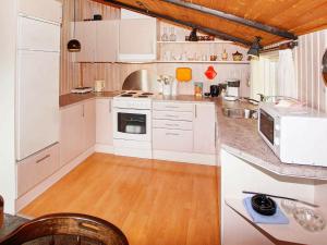 a kitchen with white appliances and a wooden floor at 4 person holiday home in Hemmet in Hemmet