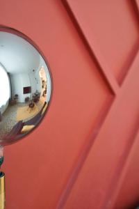 un miroir reflétant un couloir avec un mur rouge dans l'établissement Appartement au centre de Jambes-Namur Sleep & Repeat, à Jambes