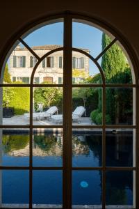 an open window with a view of a swimming pool at Hôtel particulier de Tingry - Pierres d'Histoire in Ménerbes
