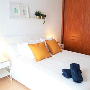 a white bed with two blue towels on it at Silver Ocean Puerto Lajas by Sea You There Fuerteventura in Puerto de las Lajas