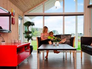 uma mulher e uma criança sentadas num sofá na sala de estar em 14 person holiday home in Sydals em Høruphav