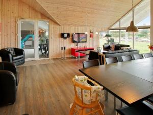 uma sala de estar com mesa e cadeiras em 14 person holiday home in Sydals em Høruphav