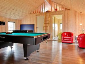 um quarto com uma mesa de bilhar e uma cadeira vermelha em 14 person holiday home in Sydals em Høruphav