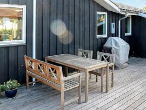 uma mesa de madeira e cadeiras num deque em 9 person holiday home in Hadsund em Nørre Hurup