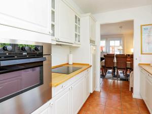 a kitchen with white cabinets and a stove top oven at 4 person holiday home in Bl vand in Blåvand