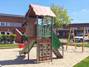 einen Spielplatz mit Rutsche in einem Park in der Unterkunft 6 person holiday home on a holiday park in Hemmet in Hemmet