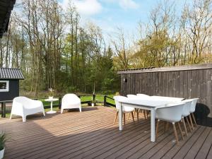 una terraza con una mesa blanca y sillas. en 6 person holiday home in Odder, en Odder
