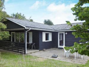 ノーポにあるThree-Bedroom Holiday home in Nordborg 3の青い家 白い椅子2脚