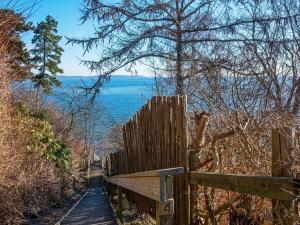 un sentiero in legno con una recinzione e l'oceano sullo sfondo di 10 person holiday home in B rkop a Egeskov