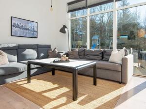 14 person holiday home in Glesborg في Glesborg: غرفة معيشة مع أريكة وطاولة قهوة