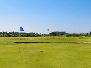 a golf course with a blue flag on the green at 6 person holiday home in Ringk bing in Søndervig
