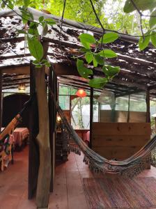 a hammock in the middle of a building with a table at Mariri Jungle Lodge in Alto Paraíso de Goiás