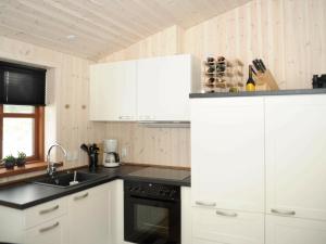 ホにある2 person holiday home in Bl vandの白いキャビネットとシンク付きのキッチン
