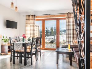 a dining room with a table and chairs and a balcony at Anielska Osada in Groń