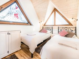 two beds in a room with a window at Anielska Osada in Groń