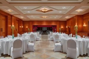 a banquet hall with white tables and white chairs at The Cascades Golf Resort, Spa & Thalasso in Hurghada +37 photos