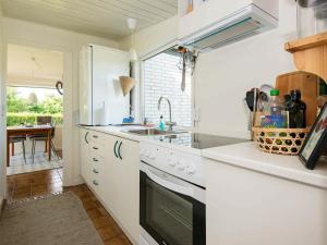 a white kitchen with a sink and a stove at 4 person holiday home in Broager-By Traum in Broager