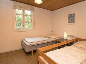 2 łóżka pojedyncze w pokoju z oknem w obiekcie 4 person holiday home in Haderslev w mieście Haderslev