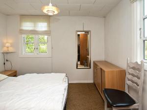 sypialnia z łóżkiem, biurkiem i lustrem w obiekcie 4 person holiday home in Haderslev w mieście Haderslev
