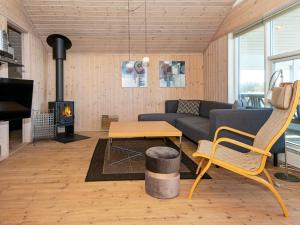 a living room with a couch and a table and a fireplace at 6 person holiday home in Ringk bing in Nørby