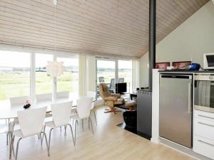 Brovstにある6 person holiday home in Brovstのキッチン、ダイニングルーム(テーブル、白い椅子付)