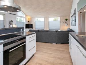 a kitchen with a stove and a couch in a room at 6 person holiday home in V ggerl se in Bøtø By