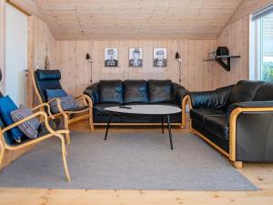 a living room with a couch and a table and chairs at 6 person holiday home in Ringk bing in Ringkøbing