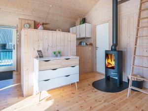 a living room with a fireplace in a log cabin at 6 person holiday home in Ringk bing in Ringkøbing
