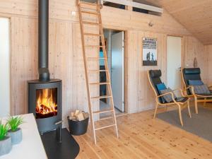 a living room with a fireplace and a ladder at 6 person holiday home in Ringk bing in Ringkøbing