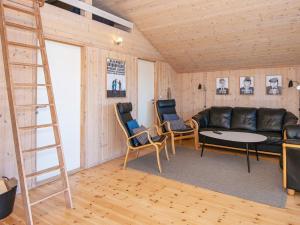 una sala de estar con un sofá de cuero negro y sillas en 6 person holiday home in Ringk bing, en Ringkøbing