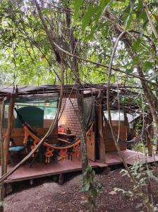une cabane dans les arbres avec une véranda dans les bois dans l'établissement Mariri Jungle Lodge, à Alto Paraíso de Goiás